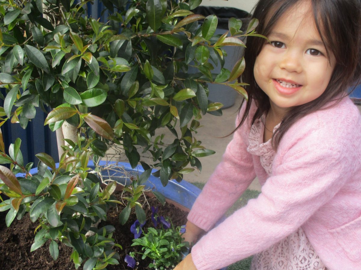 A smiling preschooler in the garden at Creative Center for Children